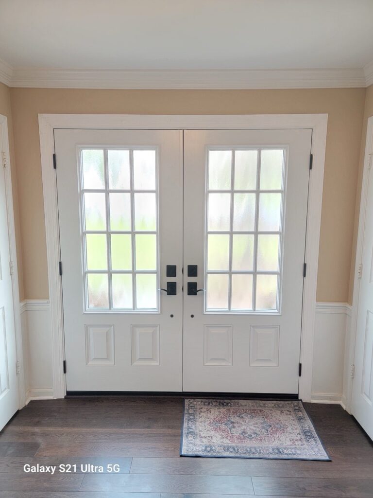 White double french patio doors with multi-pane glass viewed from inside the home.
