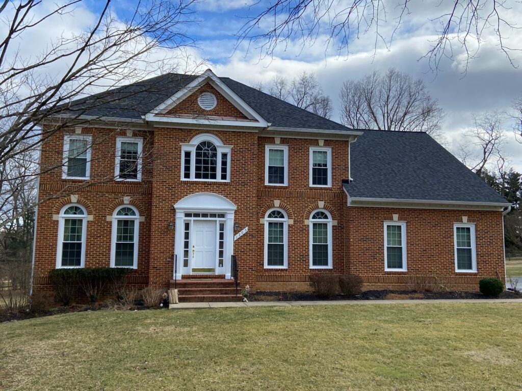 Brick colonial with three arched palladian-style windows and a front porch.
