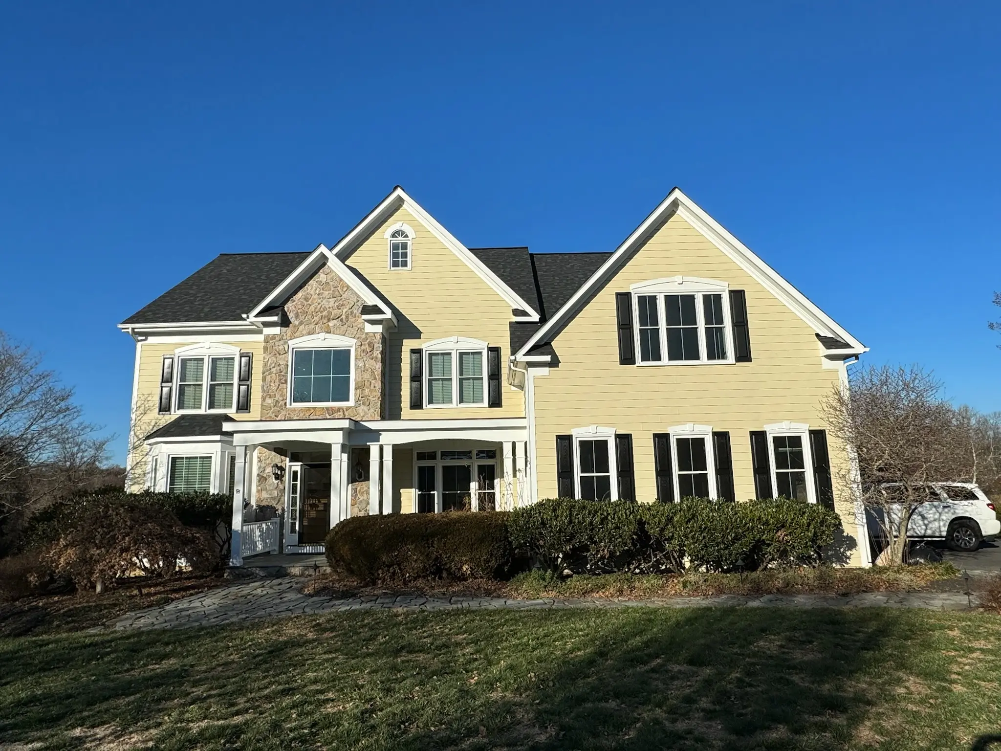 Yellow siding craftsman with stone accents