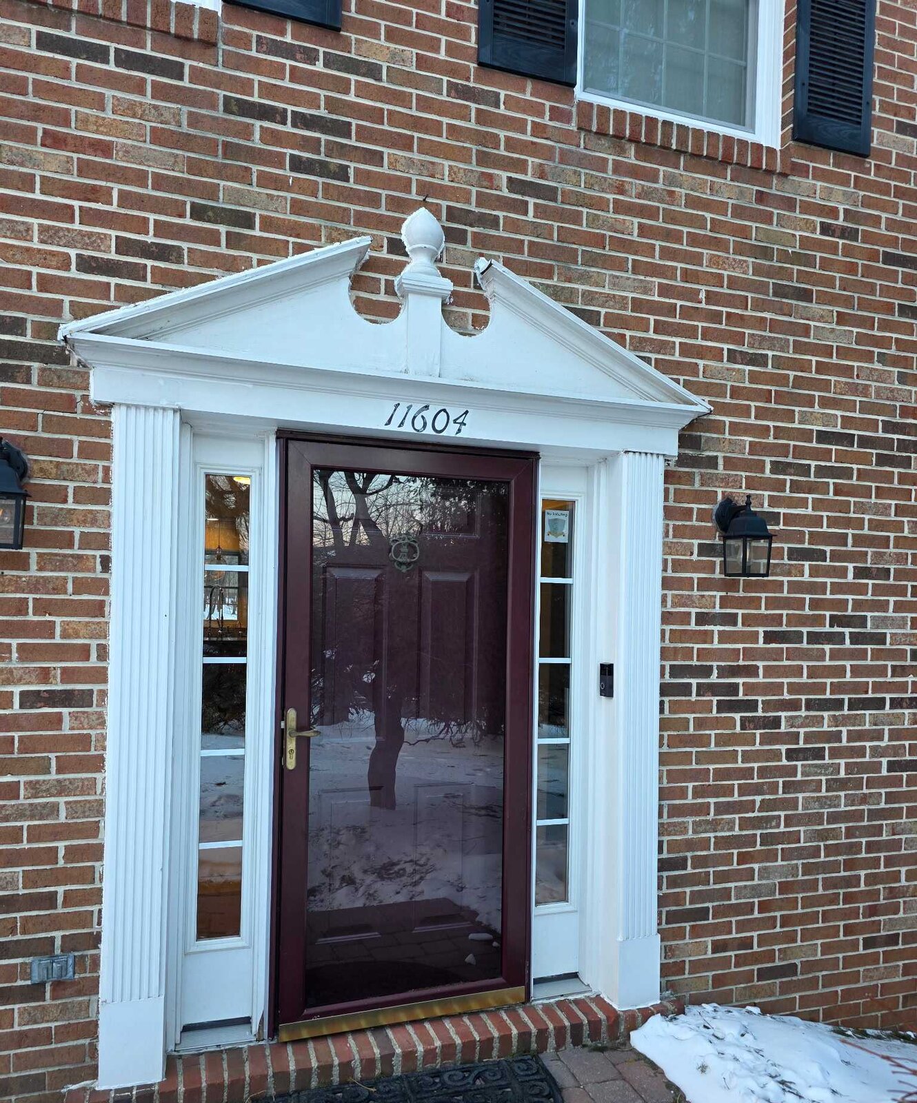 Brick colonial with its original burgundy entry door before replacement