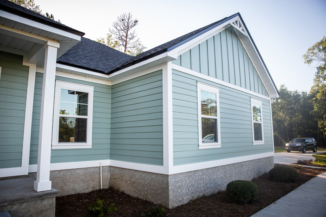 Fiber cement lap siding and board-and-batten gable in seafoam with white trim
